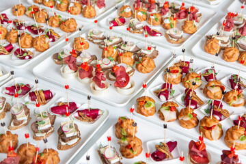 Catering buffet or service with different snacks, appetizers and canapes on a table. Variety of Freshly Prepared Catering Food for an Event.