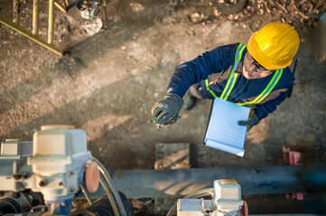Top view photo of maintenance engineer performing inspection on machinery.