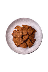 Crispy homemade brown bread chips with seeds and grains, salt, spices