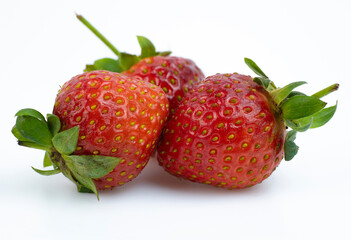 Ripe strawberries clustered together on a white surface
