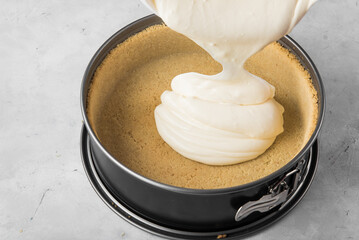 Making cheesecake. Pour the cheesecake mixture into the baking dish.
