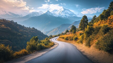 Stunning scenic road with snow capped mountains and lush golden hued landscape in the himalayas