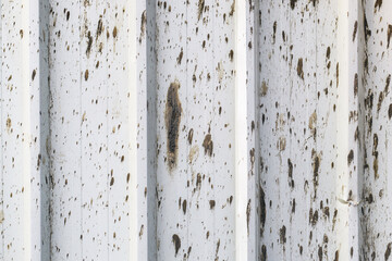 Mud stains on corrugated metal sheet surface