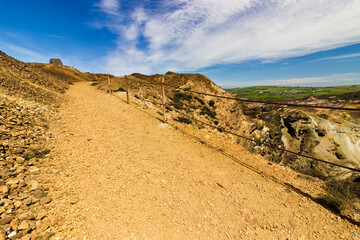 Scene from the lunar-like landscape of the copper mine trail at Parys Mountain, featuring the Grade II Listed windmill in the distance, Amlwch, Anglesey, Gwynedd