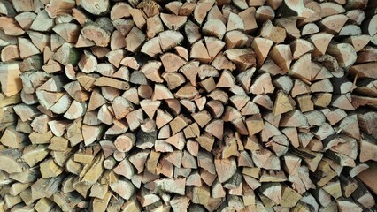 A close-up view of a neat stack of chopped firewood ready to burn, perfect for cozy winter nights.