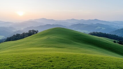 Obraz premium Sunset over rolling green hills and distant mountains (2)