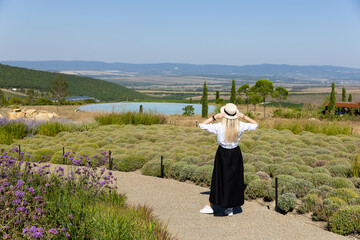Girl in a white hat looking at a beautiful mountain landscape