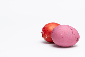Two colored  Easter eggs  on the white background  ready to be split to  friends and family for Easter. One of them is broken and other one is cracked
