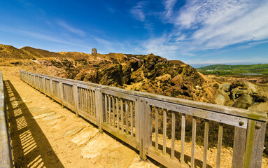 Open-cast copper mine trail footbridge scene, featuring the Grade II Listed windmill in the distance, Parys Mountain, Amlwch, Anglesey, Gwynedd