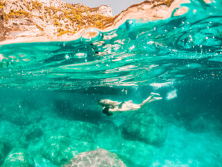 Woman swimming under water near a Boat