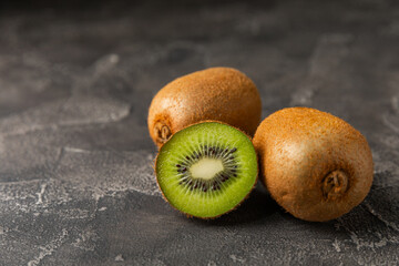 Kiwi on wooden background. Whole fruit and slices pieces of green kiwi on table. fresh ripe juicy...