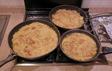 pots on the stove filled with frico, a traditional dish from the friuli region in northern italy, made with potatoes and cheese
