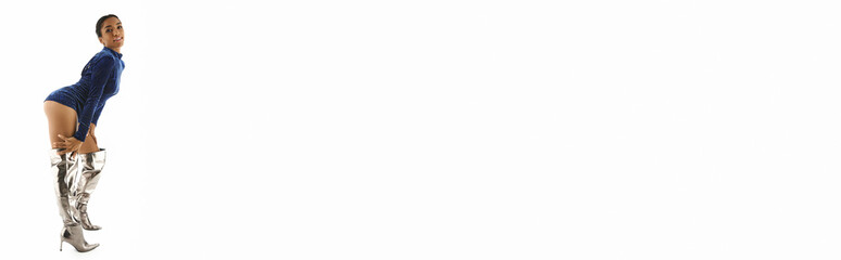 Stunning woman in elegant attire and chic silver boots in a minimalist space