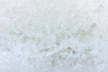 Fototapeta premium A close-up view of a textured, white surface, resembling salt crystals or a mineral deposit, showcasing a mix of rough and smooth areas.