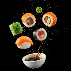 Pieces of sushi with splashes of soy sauce, isolated on black background