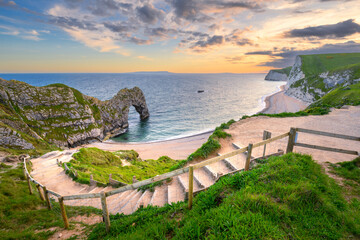 Steps leading down to Durdle Door beach on a summer evening at The Jurassic Coast, Dorset, UK.