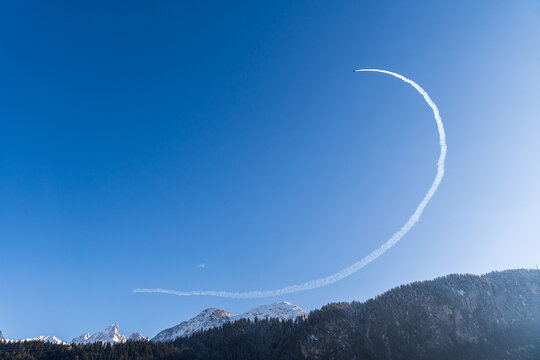 Jet Creates Dramatic Contrail Loop Against Blue Sky In Swiss