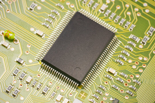 Close up of a microchip on a green circuit board