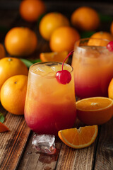 Classic tequila sunrise cocktail on an old wooden table.