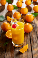 Orange juice and fresh fruits on an old wooden table.