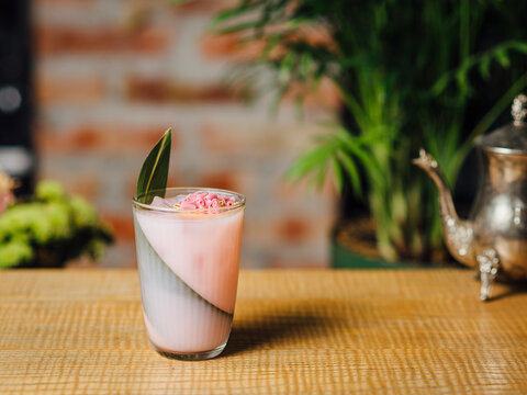 A refreshing Paradise cocktail made with white rum, rhubarb liqueur, orgeat cordial, fresh lime juice, and lemongrass cordial. A tropical-inspired drink Served  in warm bar ambiance