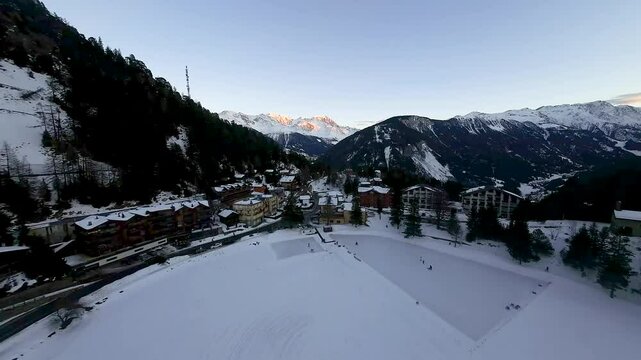 Snow-capped mountains and pristine ski trails surround Champex Lac, Switzerland, under the soft glow of sunset, offering breathtaking alpine views and winter charm.