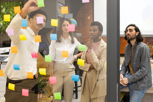 Diverse Team Collaborating with Colorful Sticky Notes in Office