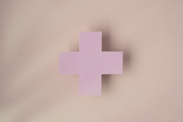 Obraz premium the symbol of the cross on a pink background, symbolizing healthcare and medical services