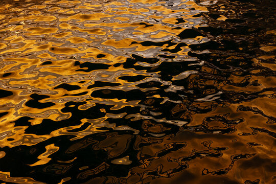 Golden water reflections at Playa Blanca Port, Lanzarote