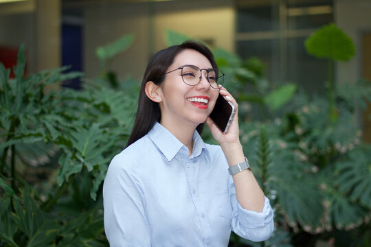 Mujer latina de negocios sonriendo en llamada telef&oacute;nica