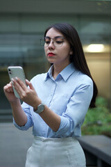 Fototapeta premium Mujer latina de negocios mirando el celular 