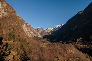 vista panoramica di un ambiente naturale tra le montagne della Slovenia nord-occidentale, di giorno, al tramonto, in inverno, con cielo sereno