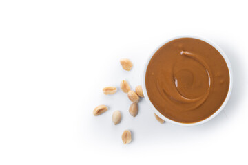 Peanut butter in a bowl isolated on white background. Top view. Copy space