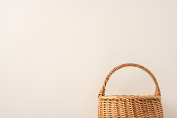 Woven wicker basket displayed against a neutral beige backdrop, representing minimalism and natural...