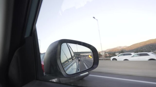 video of rear-view mirror in traffic with cars approaching and flashing the warning light at the neutral position