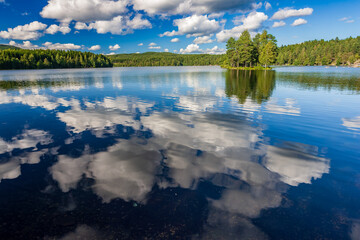 Fototapeta premium Sognsvann Lake reflects clouds and trees in Oslo, Norway on a sunny day