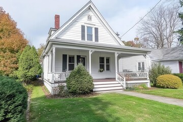 charming craftsman cottage with wraparound porch, white clapboard siding, detailed trim work, and classic architectural elements floating on white