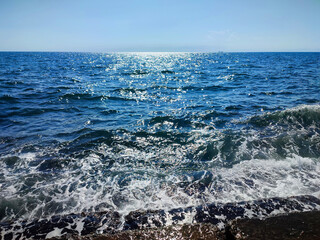 Beautiful clean sea on sunny warm day. Surface of blue calm sea with sun glare and blue sky. Sea...