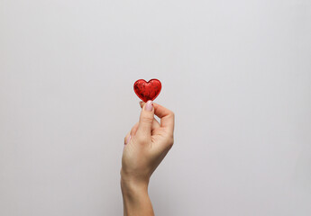 woman hand holding a red heart on white background. love concept