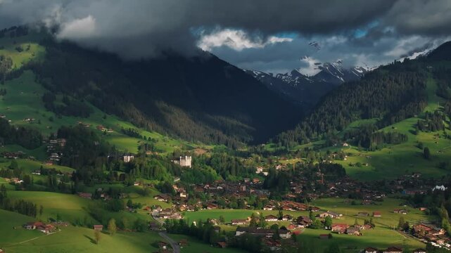 Aerial panoramic view of Gstaad mountain resort in Switzerland with clouds on the sky. Perfect for lifestyle, travel, vacation, and adventure in the Swiss Alps