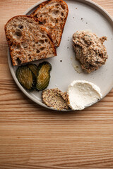 Rustic Sourdough with Smoked Fish Rillettes, Pickles, Mustard, and Whipped Cheese on a Neutral Ceramic Plate top view