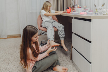 the children are wrapped in a blanket and tickling each other's heels on the bed. Family having fun...