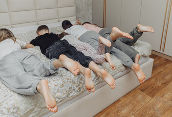 the bare, clean feet of two children, offspring, lying side by side under the same blanket on the...