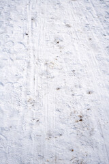 Snow-covered ground with visible footprints and trails, showcasing winter season's backdrop and the texture of ice and snow underfoot, revealing human activity in a snowy landscape.