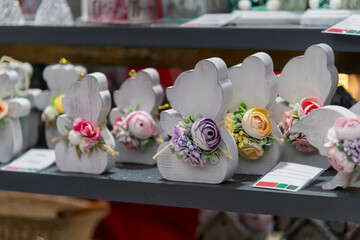 Handcrafted wooden decorations with floral designs on display at a street market