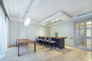 Elegant design of the kitchen, decorated in bright colors. Double-leaf door with glass windows. Stylish furniture.