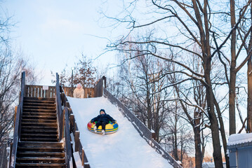 children at snow tubing. slide from snow hill. winter activity