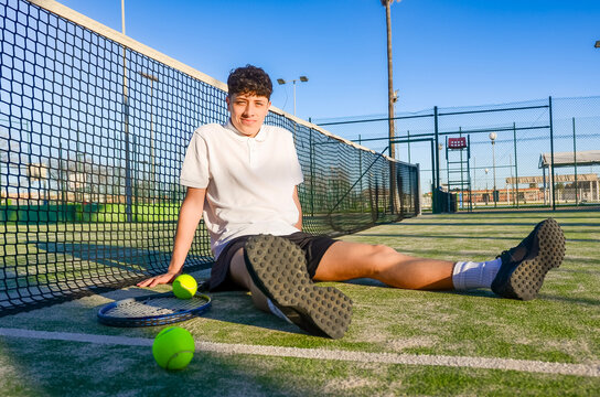 Young tennis player resting after training on padel court - Powered by Adobe