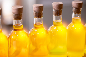 Glasses bottles of organic fresh sunflower vegetable oil on blur background
