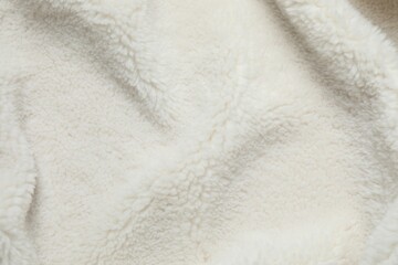 White cuddle teddy bear fabric as background, top view